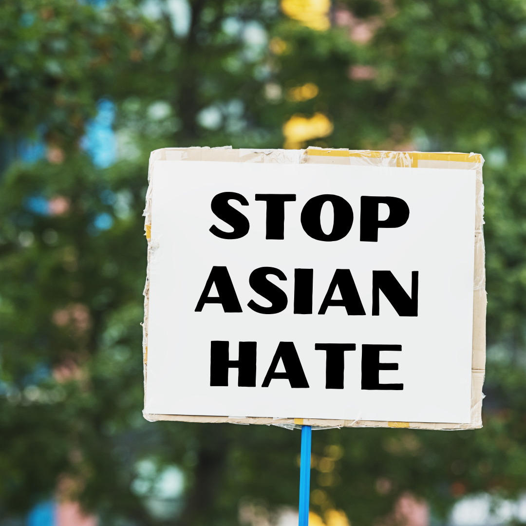 Sign Black on White reading Stop Asian Hate Sign with green background