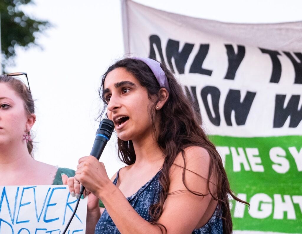 Soraya Bata speaking with microphone in hand