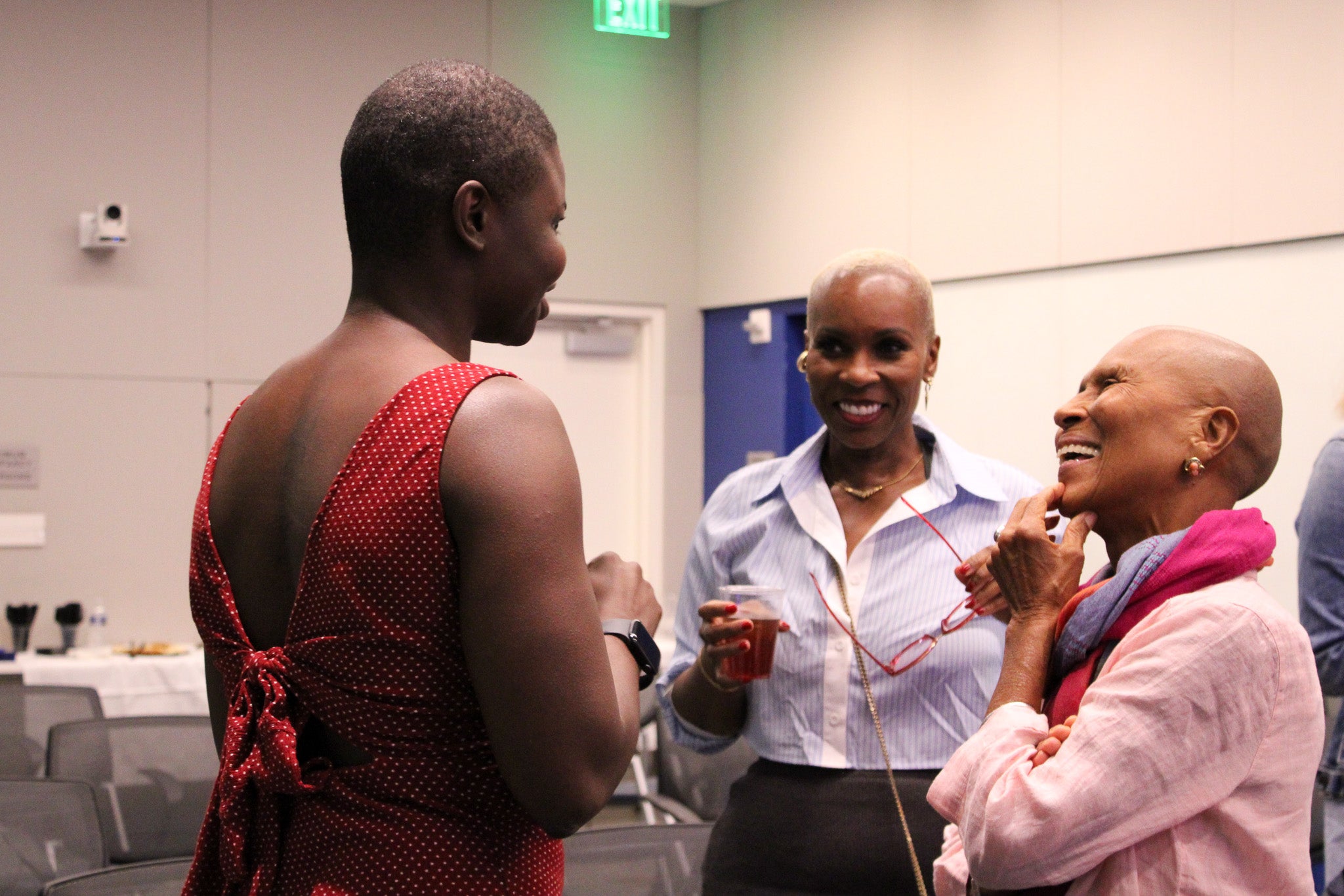 Dr. McFadden is talking with two black women after the lecture.