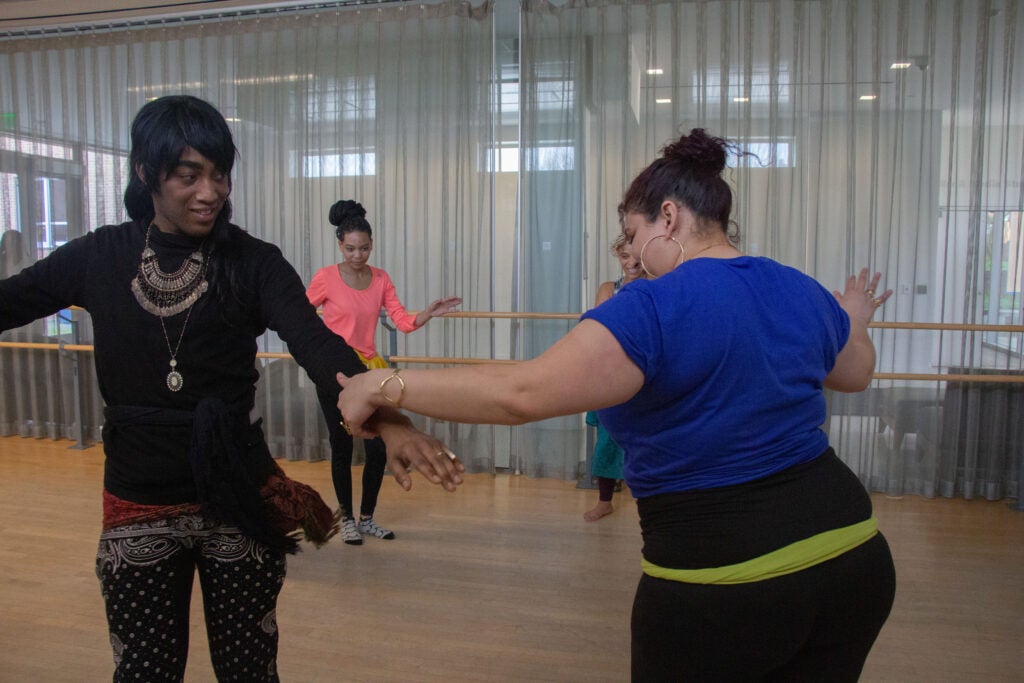 Warda and a dance participant dance together in joy.