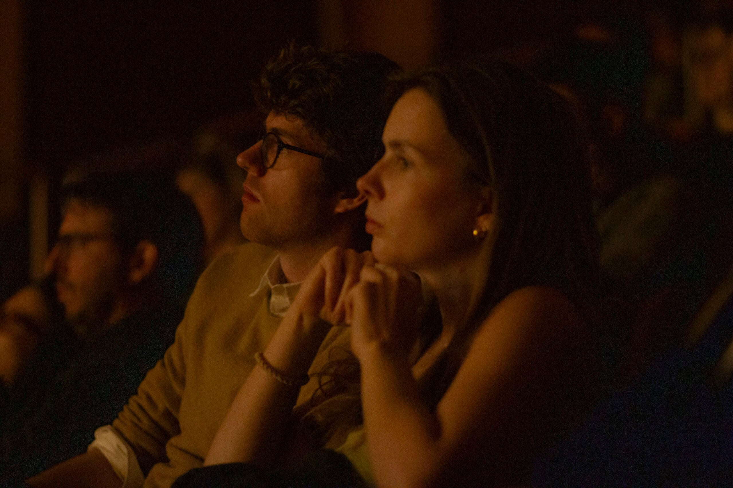 Audience members in a dark room, watching the film.