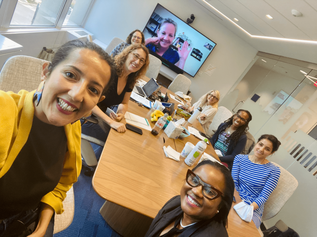 8 members of the Gender+ Justice Initiative team smiling for a group picture.