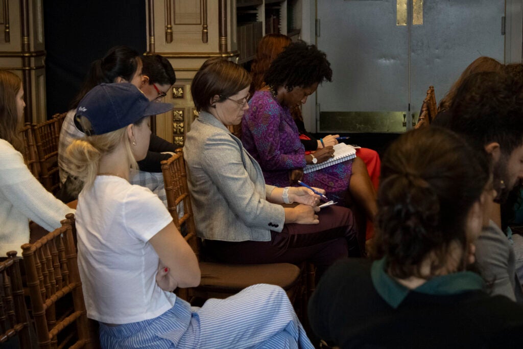 Colloquium attendees are listening attentively to the panelists' presentations.