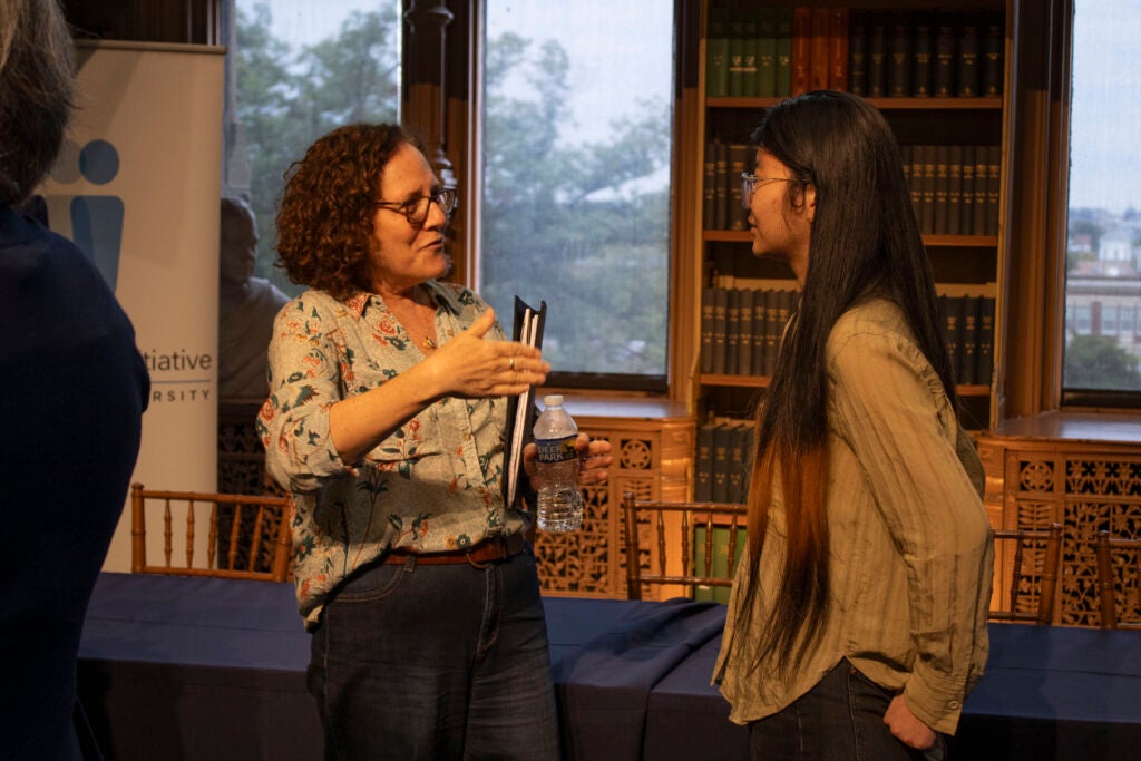 Naomi Mezey, a law professor and panelist on the Health Equity panel, is engaged in conversation with a colloquium attendee. 