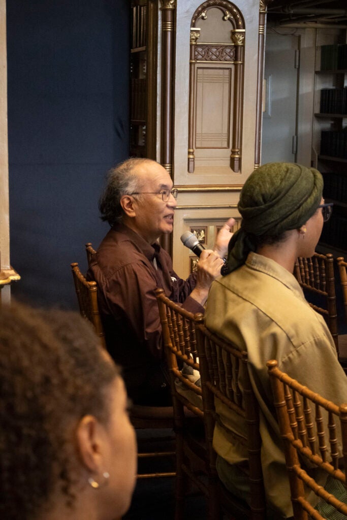 An audience member is posing a question to the panelist.