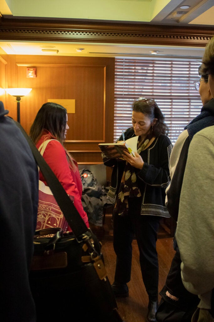 Dr. Adely autographs someone's copy of her book.