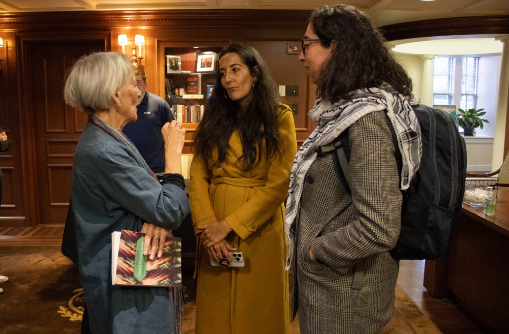 Dr. Melyssa Haffaf, Executive Director of G⁺JI, and 24-25 G⁺JI Fellow Samar Saeed are engaged in conversation with an audience member holding a copy of Dr. Adely's book.